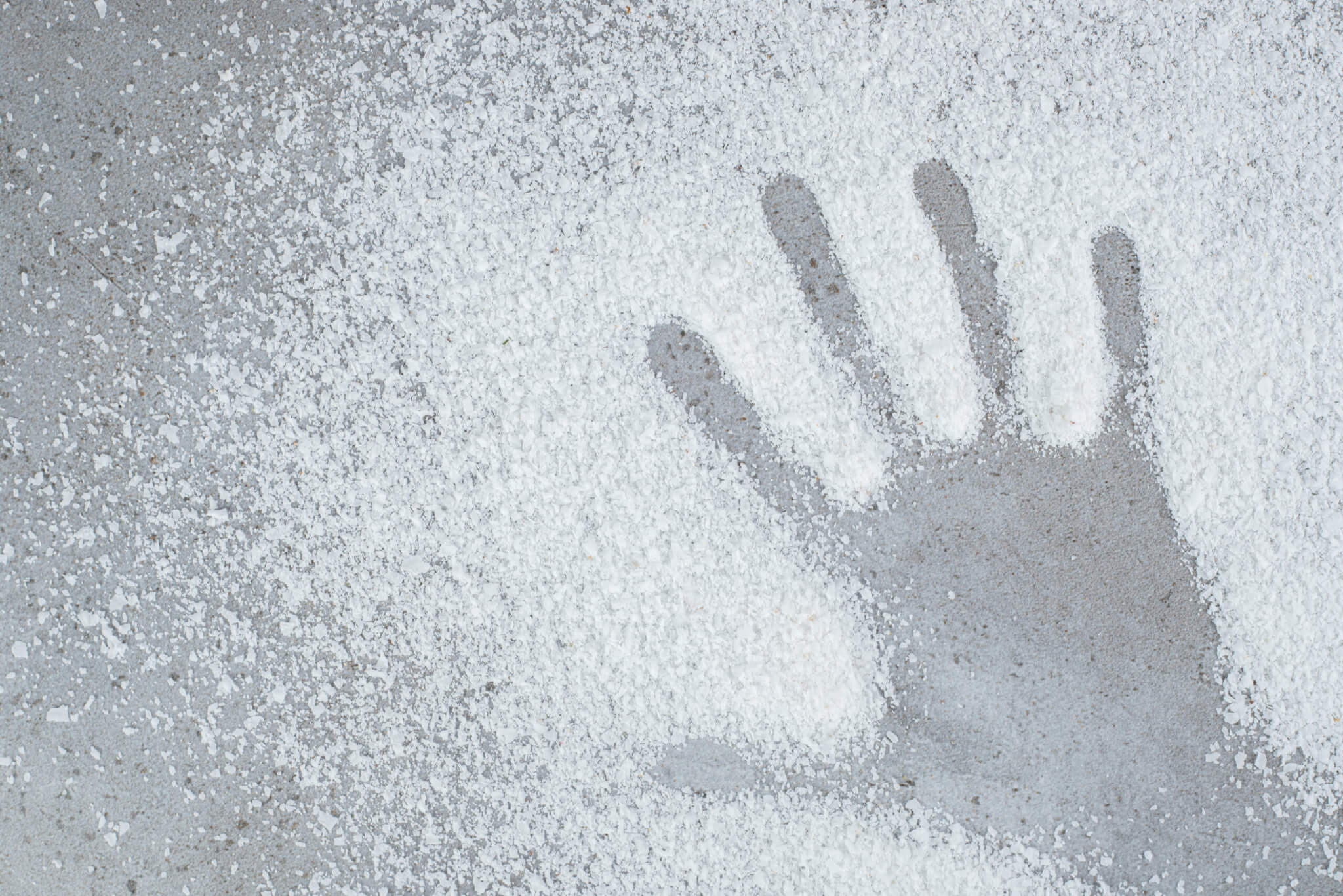 Hand print left in a pile of coconut powder on marble background