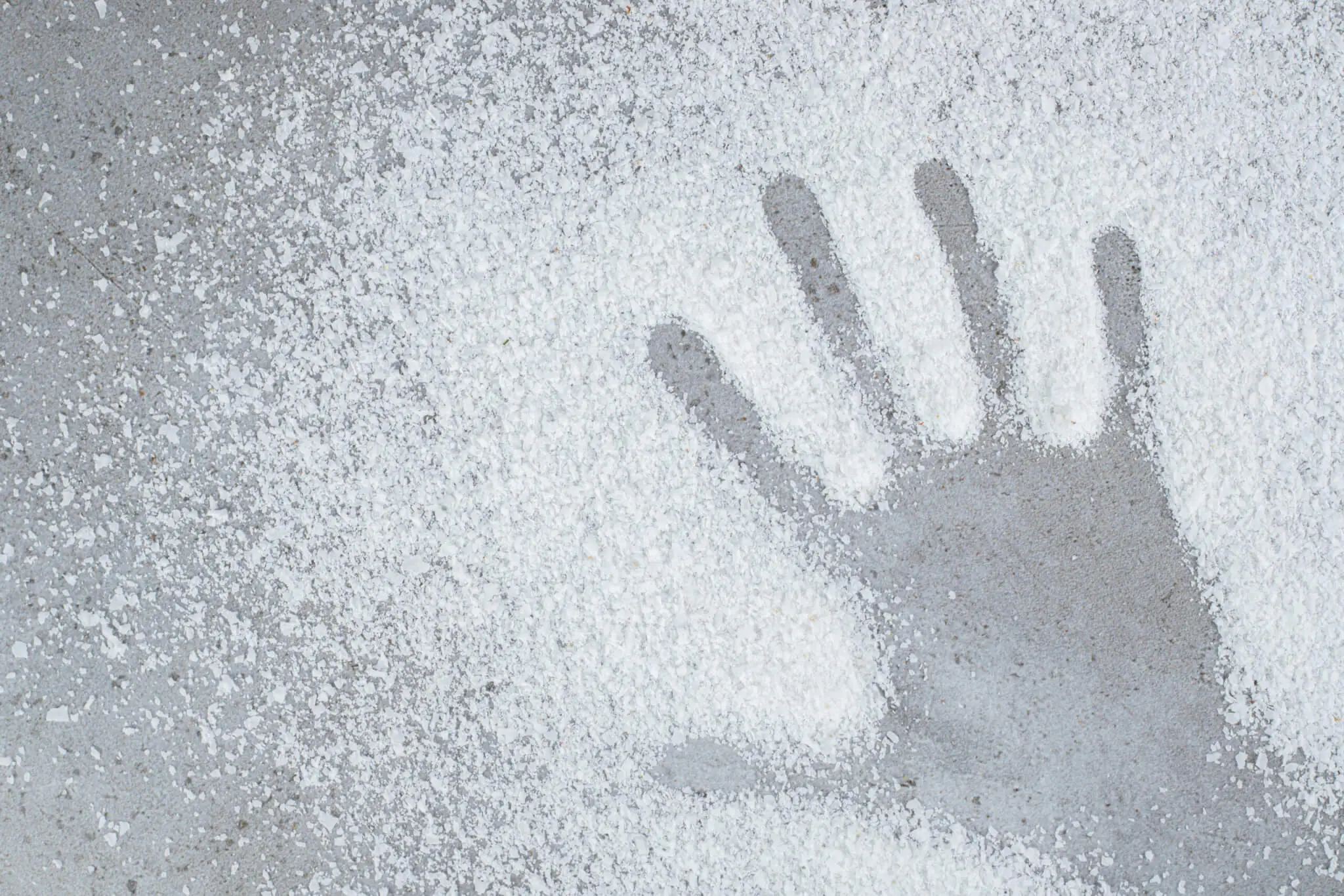 Hand print left in a pile of coconut powder on marble background